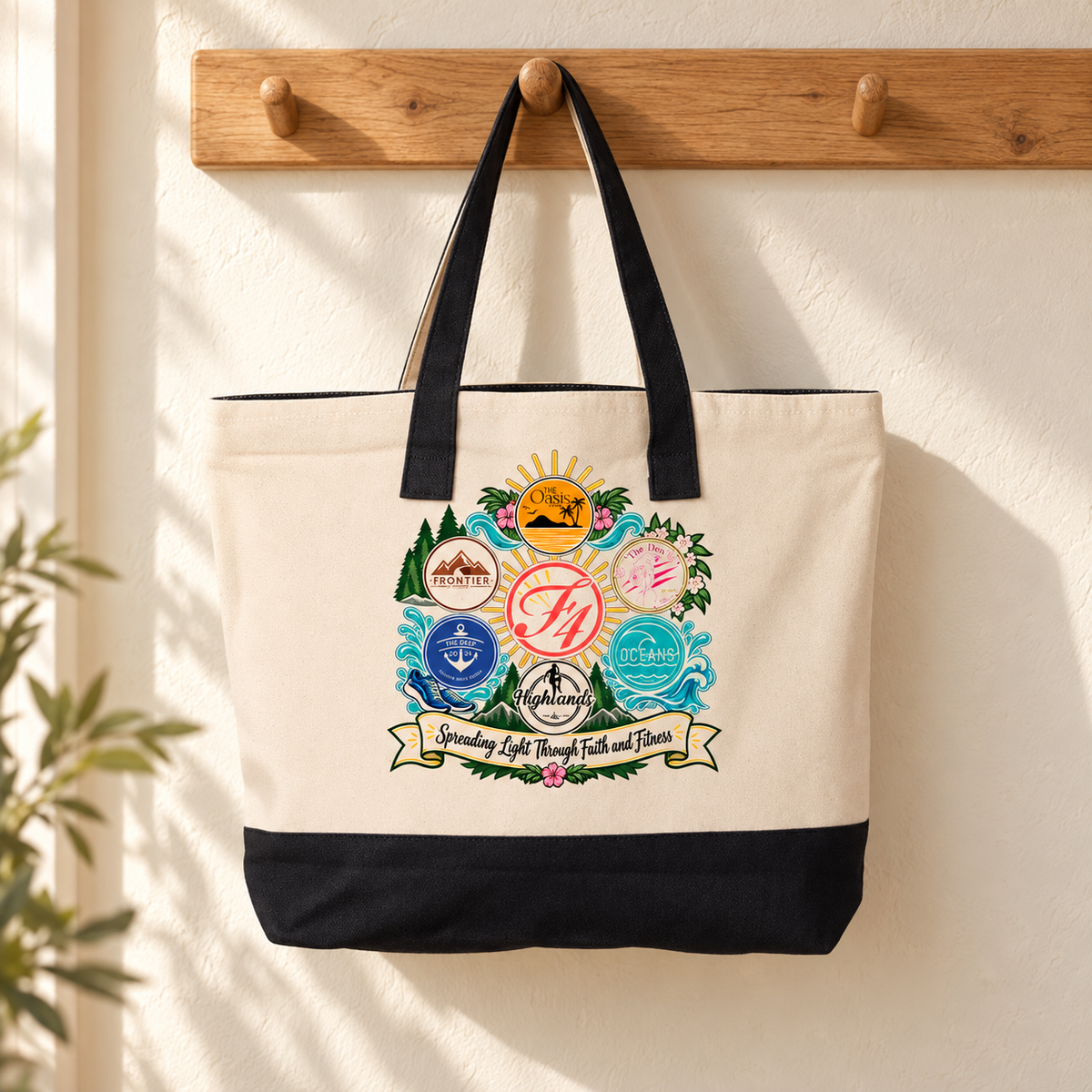 F4 Community canvas tote with black handles hanging from an oak peg in a warm cream entryway