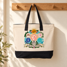 F4 Community canvas tote with black handles hanging from an oak peg in a warm cream entryway
